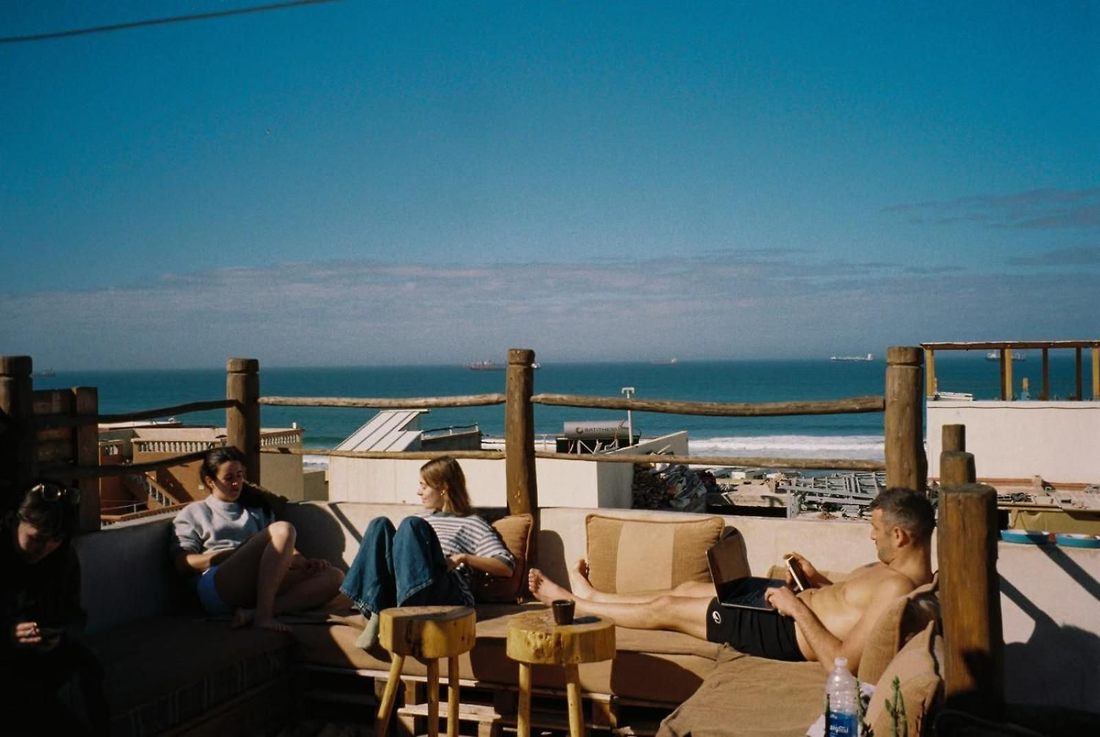 Guests lounging on the rooftop with the harbour visible beyond
