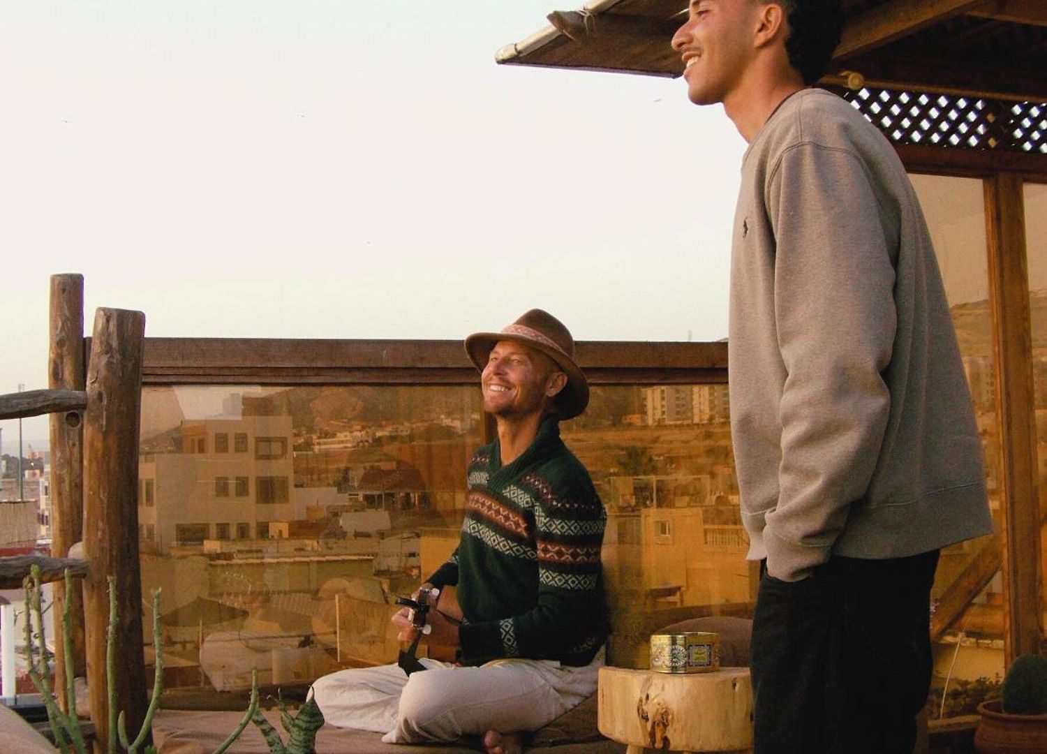 Guitar moment between guests on the rooftop at dusk