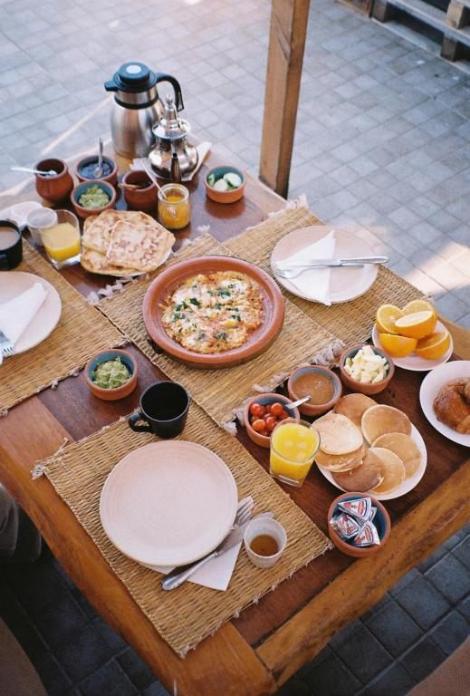 Breakfast spread: teapot, msemen pancakes, eggs, fruit and juices